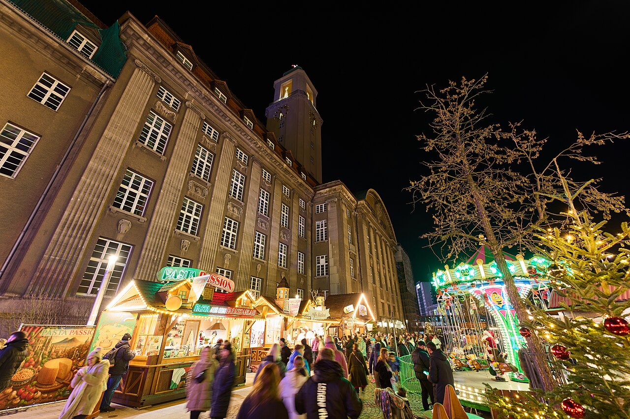 Beleuchtete Marktbuden vor dem Rathaus Spandau bei Nacht